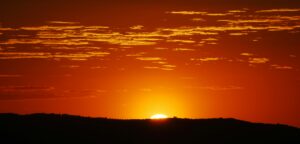 Photo of sun setting over a mountain. 