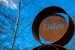 The word "listen" carved into a sign.